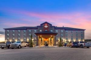 a hotel with cars parked in a parking lot at Best Western Plus Drayton Valley All Suites in Drayton Valley