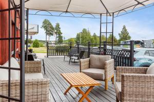 un patio con sillas, mesas y una sombrilla en Best Western Hotell SoderH, en Söderhamn
