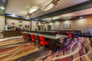 a restaurant with a large table and red chairs at Best Western Plus Drayton Valley All Suites in Drayton Valley
