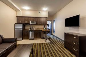 a large kitchen with a couch and a tv at Best Western Plus Drayton Valley All Suites in Drayton Valley