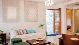 salon z białą kanapą i żyrandolem w obiekcie Villa Mathios w mieście Pigianos Kampos +24 zdjęcia