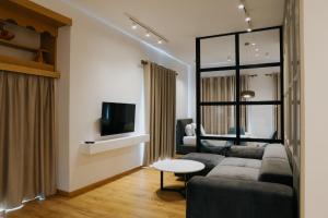 sala de estar con sofá y TV en Sharm Hotel Luxury, en Gjirokastra