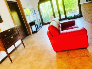 a red chair sitting in a living room at Residenza Locci - Rooms & Apartments in Teulada