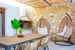 un patio con tavolo e sedie in legno di Villa Mathios a Pigianos Kampos