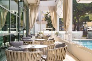 um restaurante com mesas e cadeiras e uma piscina em Hotel Continental em Rimini