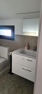 uma cozinha branca com um lavatório e um WC em Ático Corazones em Granada