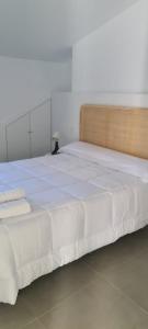 uma grande cama branca com uma cabeceira de madeira em Ático Corazones em Granada