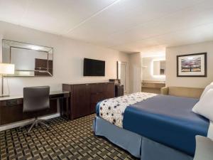 a hotel room with a bed and a desk at Rodeway Inn in Greenwood