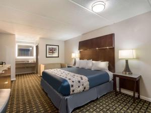 a hotel room with a large bed and a desk at Rodeway Inn in Greenwood