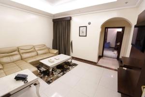 ein Wohnzimmer mit einem Sofa und einem Tisch in der Unterkunft قصر اليمامة للشقق المخدومة Al Yamama Palace Serviced Apartments in Yanbu