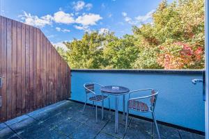 a patio with two chairs and a table on a blue wall at Forty Four Main Street in Swords