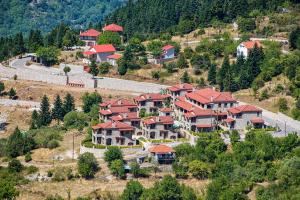 a group of houses with red roofs on a hill at Omalia Village in Áno Khóra