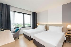 a hotel room with two beds and a window at Best Western Nada Don Mueang Airport hotel in Bangkok