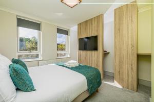 a bedroom with a bed and a flat screen tv at Forty Four Main Street in Swords