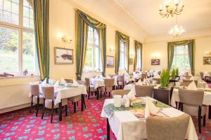 a dining room with white tables and chairs at Ferien Hotel Villa Südharz in Sülzhayn