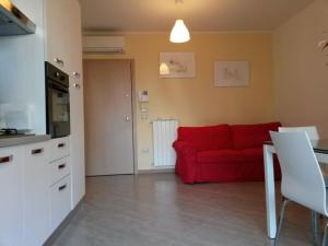 uma sala de estar com um sofá vermelho e uma cozinha em Esclusivo appartamento alle Dune! Dalla piscina alla spiaggia in 30 mt! em Silvi Paese