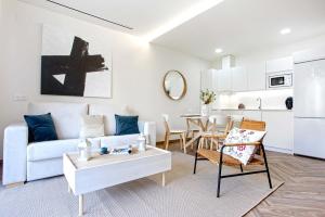 a living room with a white couch and a table at Genteel Home Magdalena in Seville