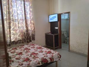 a bedroom with a bed and a tv in a room at Hotel Moon Star, Panipat in Pānīpat