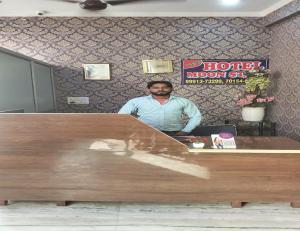 a man standing behind a counter in a hotel room at Hotel Moon Star, Panipat in Pānīpat