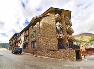 ein großes Backsteingebäude an der Straßenseite in der Unterkunft Apartamento rodeado de Natura y Actividades en Canillo HUT-7852 in Canillo