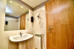 ein Badezimmer mit Waschbecken und Holztür in der Unterkunft Apartamento junto a pistas en Canillo 2-8 HUT-7852 in Canillo + 16 Fotos