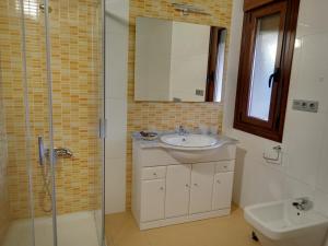 a bathroom with a sink and a shower and a toilet at PENSIÓN RÚSTICA SANTA MARIÑA DA PONTE in Santa Marina del Puente