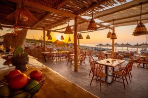 a restaurant with tables and chairs and a view of the ocean at Aliv stone suites & spa in Agios Nikolaos