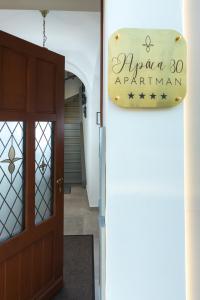 a sign that reads napa apartment next to a door at Apáca 30 Apartman **** Győr in Győr