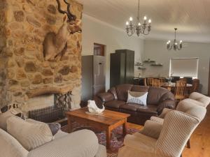 a living room with couches and a stone wall at Zungah Lodge in Uitenhage
