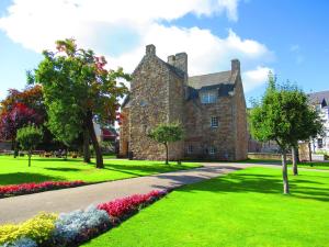an old stone house with flowers in a park at Huge 4 Bed Apt - Perfect Base to Explore The Borders in Jedburgh