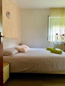 Un dormitorio con una cama con una almohada verde. en Appartamento Verdebleu - Lago e Terme, en Levico Terme