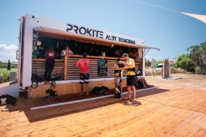 a group of people standing outside of a food truck at ProKite Alby Rondina - RESORT - in Birgi Vecchi