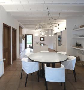 a kitchen and dining room with a white table and chairs at White House Ibiza Modernist Design Can Perez Sea views Es Figueral in Santa Eularia des Riu