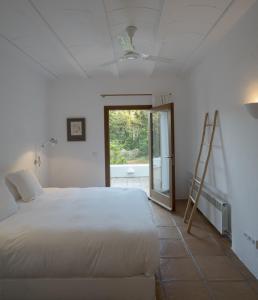 a bedroom with a bed and a ladder and a window at White House Ibiza Modernist Design Can Perez Sea views Es Figueral in Santa Eularia des Riu