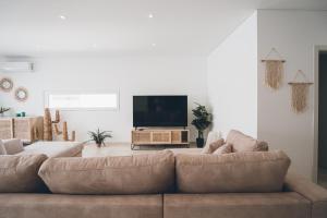 sala de estar con sofá y TV de pantalla plana en Antica Villa en Ribamar