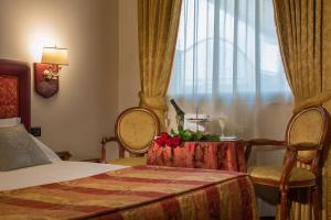 Schlafzimmer mit einem Bett, einem Tisch und einem Fenster in der Unterkunft Hotel Motel Del Duca in Cava Manara