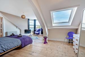 a bedroom with a bed and a window at Dizzy Heights Swanage Sleeps 10 with Amazing Views in Swanage