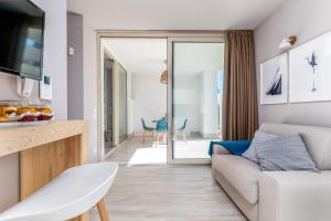 a living room with a couch and a table at Mare Villas Pescoluse- Design Apartment in Marina di Pescoluse