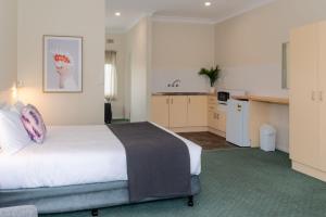 a hotel room with a bed and a kitchen at Pacific Motel 10 in Forster