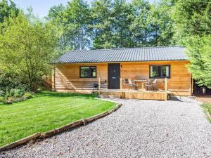 a log cabin with a patio and a yard at Willowbeck Lodge in Settle