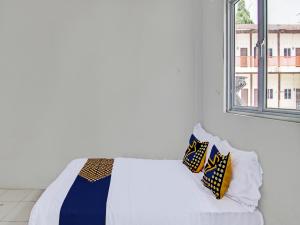 Cama en habitación con ventana en SPOT ON 91828 Homestay Dinda Syariah, en Parit