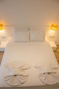 een wit bed met twee handdoeken erop bij Aloha Suites in Marmaris