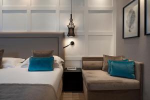 ein Schlafzimmer mit zwei Betten und einer Couch mit blauen Kissen in der Unterkunft Hotel Lungomare in Riccione