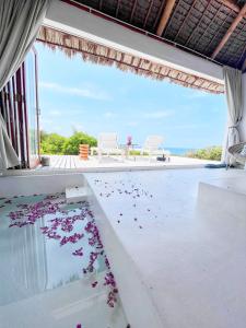 a room with a pool with flowers on the floor at Mar-Me-Quer, Eco Beach Retreat in Inhambane