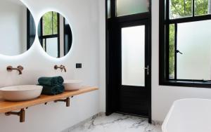 uma casa de banho com 2 lavatórios e um espelho em Boutique Hotel De Salon em Haia