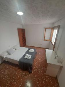 Schlafzimmer mit einem Bett, einem Tisch und einem Fenster in der Unterkunft Gran apartamento con la playa a 2 kilómetros para familias in San Juan de Alicante