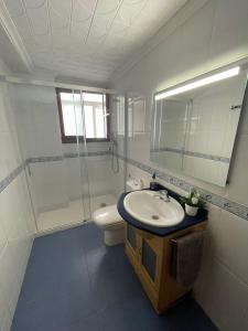 ein Badezimmer mit einem Waschbecken, einem WC und einem Spiegel in der Unterkunft Gran apartamento con la playa a 2 kilómetros para familias in San Juan de Alicante