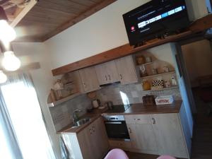 a kitchen with a sink and a tv on the wall at Villa Gianna in Karpenisi