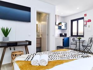 a bedroom with a bed and a desk in a room at CASINHA DE FERRAGUDO - Terraço Privado, AC, WiFi, Centro 250m in Ferragudo