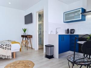 een keuken met een blauwe kast en een wastafel bij CASINHA DE FERRAGUDO - Terraço Privado, AC, WiFi, Centro 250m in Ferragudo